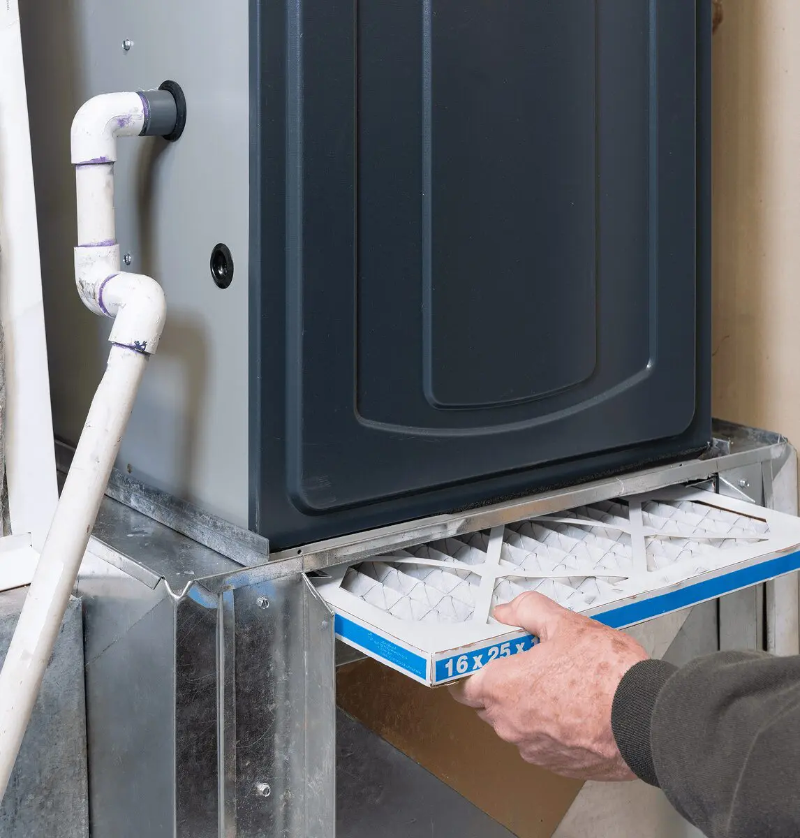 Person installing air filter in furnace.
